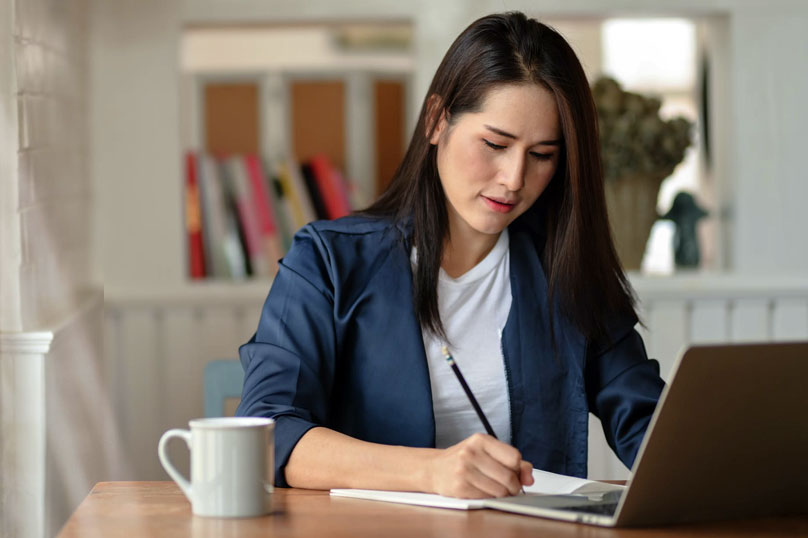 woman with pencil writing on paper