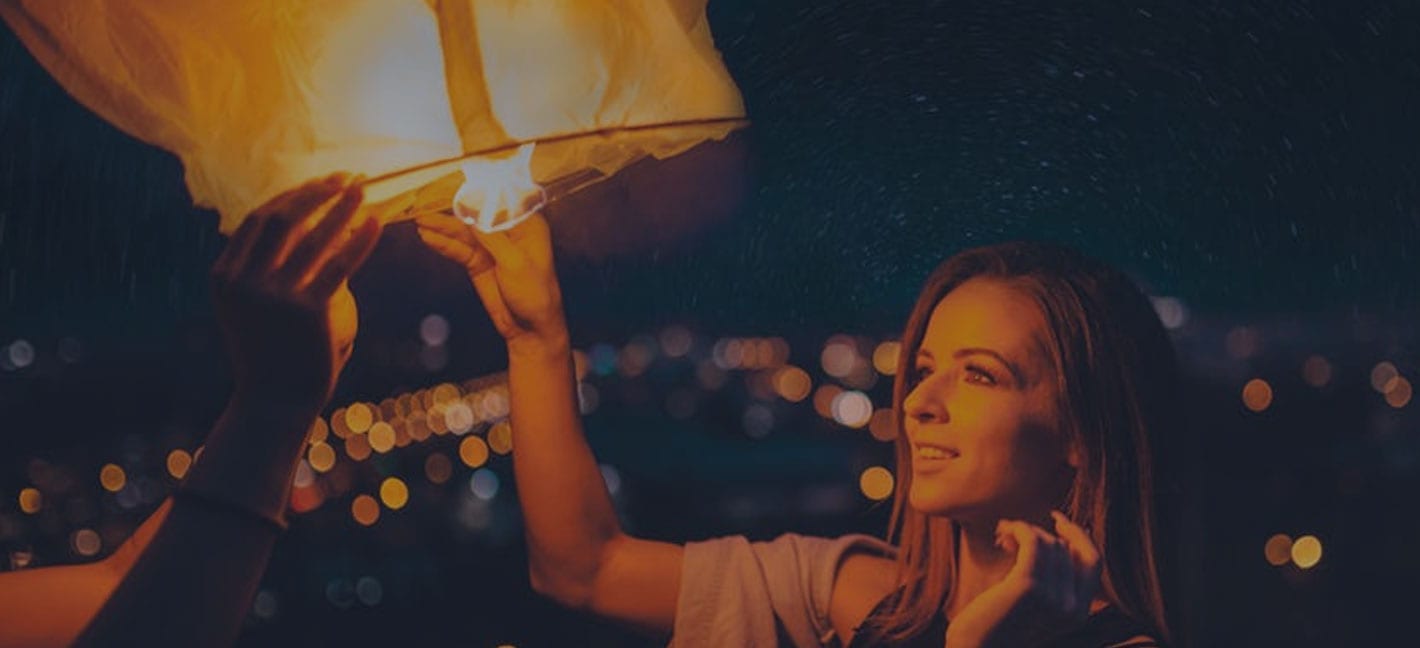 Woman holding lantern symbolising travel and discovery with Qantas Points